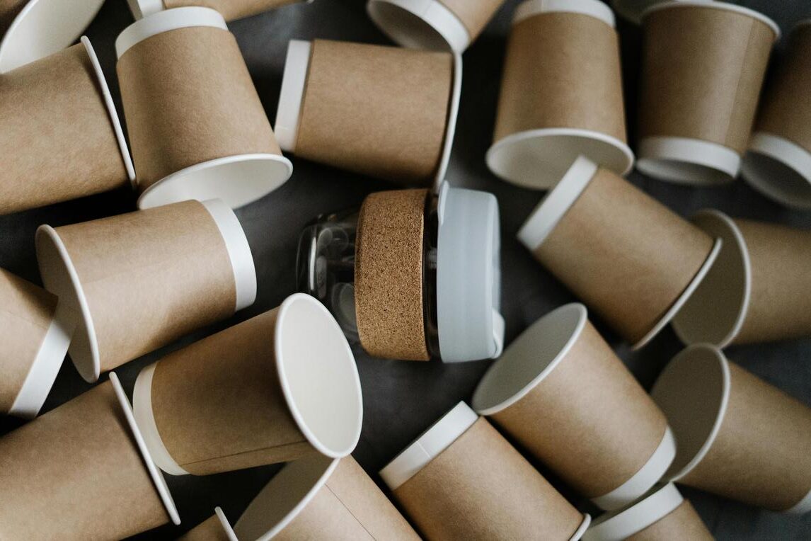 Reusable cup surrounded by disposable cardboard cups